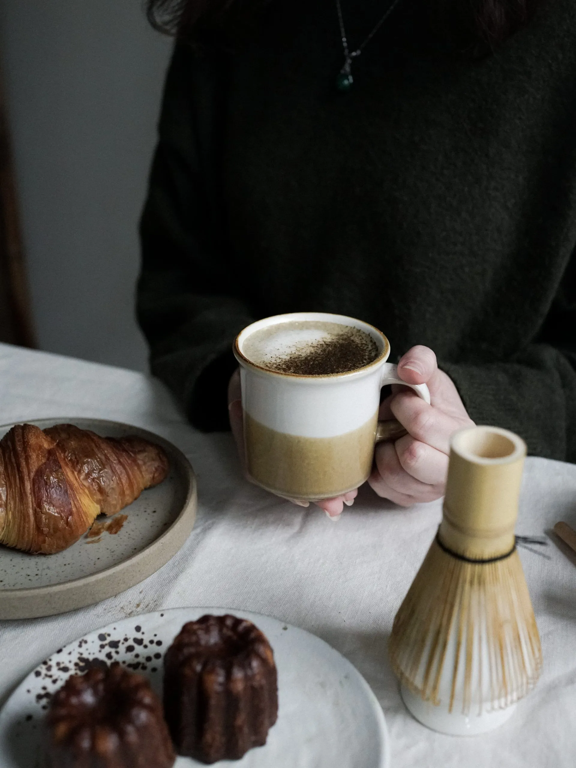 A person holding a cup of Ceremonial Matcha Tea Latte